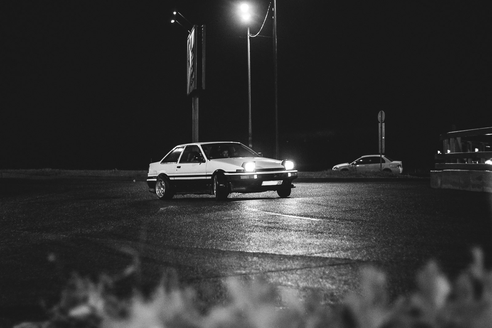 AE86 drifting under lights at a night session