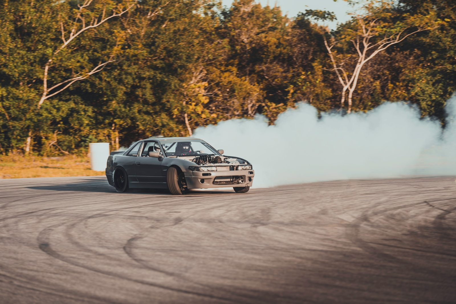 Silvia S13 laying down a smoke trail mid-drift
